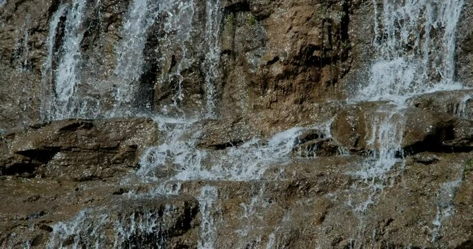 Peaceful waterfall scene on a cloudless sunny day, birds flying. Static