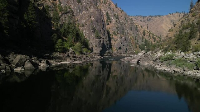 Aerial above beautiful and calm Salmon River in Nez Perce National Forest in Idaho on sunny blue sky day