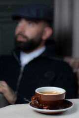 Coffee cup in coffee shop. Man with beard and mustache sitting in cafe and drinking coffee.