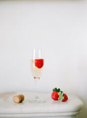 champagne and strawberries on white background with space for copy
