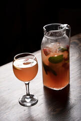 Cocktail in a glass with ice and mint on a wooden table
