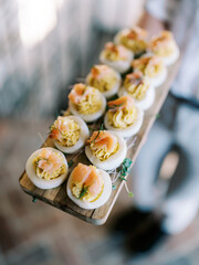 deviled egg appetizer with smoked salmon on wood board