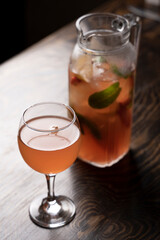 Cocktail in a glass with ice and mint on a wooden table