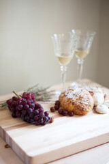 grapes and bread on cutting board with wine glasses