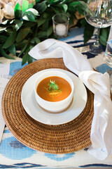 tomato soup in white bowl at place setting