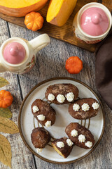 Chocolate rum potato cake with pumpkin on rustic background, homemade vegan dessert. Traditional Eastern European dish with cocoa and butter. Chocolate sweets filled with marzipan. View from above.