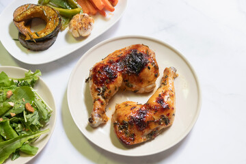 Succulent grilled chicken legs served with fresh vegetables and savory sides.