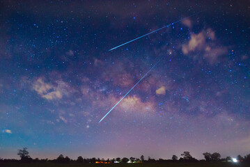 Naklejka premium meteorites fly in the night sky. Bright meteors glow in the atmosphere. Beautiful shooting stars.