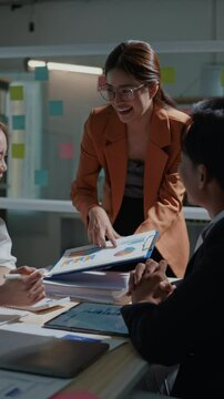 Vertical footage of Group of teamwork businesspeople are excited  happy and cheerful clap to success and achievement on business financial and marketing after working on laptop and paperwork in office