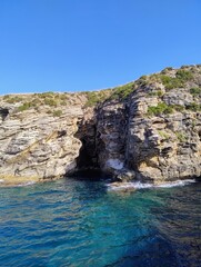 Beautiful mysterious cave. Sicilian nature. Boat trip around the sicilian coast. Magnificent cliffs. Blue transparent sea. Ocean colors. Italian summer in Europe. Hot weather.