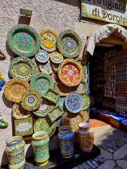 Erice ceramics. Souvenir shop. Colorful ceramic plates. Traditional sicilian aesthetics. Sicily history. Italian life. Beautiful summer day. Decorations.