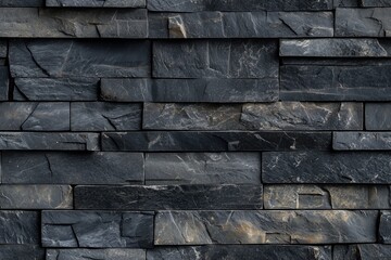 Naklejka premium Textured artesia stone cladding wall made of dark slate tiles, showcasing various shades of gray and subtle gold veining.