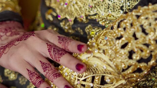 The bride's hands decorated with henna. There are many different names for henna tattoos around the world, such as mehndi, inai, hina, camphire, and hena