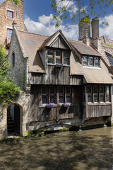 Picturesque view of water channels of the city near Beguinage Houses (Begijnhof), Bruges, Belgium