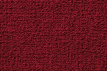 Texture of a cotton chenille red surface with a bumpy, granular appearance, resembling a fabric or material with small raised dots.