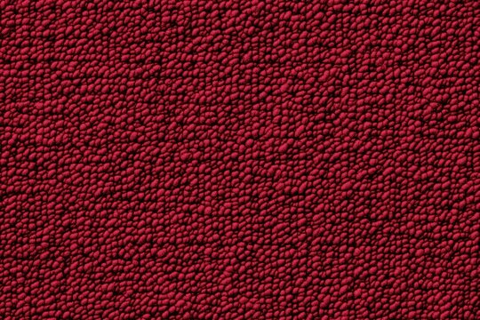 Texture of a cotton chenille red surface with a bumpy, granular appearance, resembling a fabric or material with small raised dots.