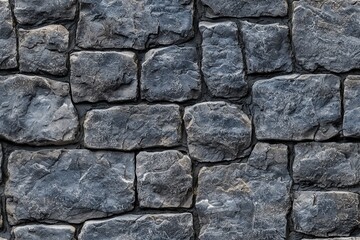 Fototapeta premium Textured coursed stone cladding wall made of irregularly shaped gray stones. The stones vary in size and shape, creating a natural and rustic appearance.