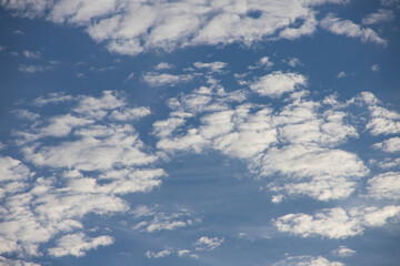 Panoramic view of clear blue sky and clouds, Blue sky background with tiny clouds. White fluffy clouds in the blue sky. Captivating stock photo featuring the mesmerizing beauty of the sky and clouds.