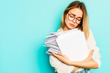 Woman with glasses holding a stack of papers looking sad.