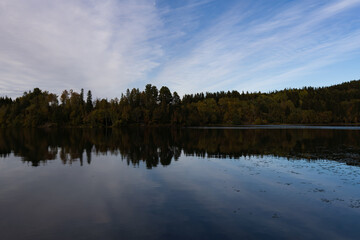 Stunning views of a beautiful sunset or sunrise over a pond or lake in spring or early summer in the evening. Reflecting water.