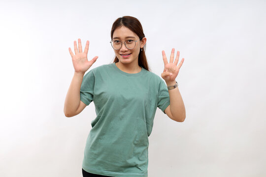 Smiling happy good-looking asian girl giving advice, showing nine fingers as explain rules, make point, standing white background