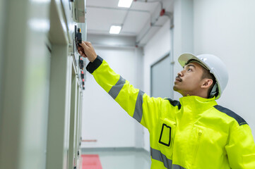Electrical engineer man checking voltage at the Power Distribution Cabinet in the control room,preventive maintenance Yearly,Thailand Electrician working at company