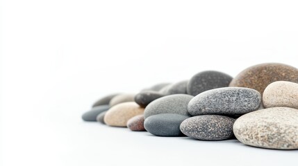 A collection of smooth river rocks arranged on a white background. The rocks are various shades of grey, brown, and black, creating a natural and calming aesthetic. This image symbolizes peace, tranqu