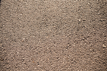 Close-up of European asphalt texture, featuring a smooth yet rugged surface with road markings and wear, ideal for urban design, transportation, or roadwork backgrounds.

