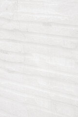 Fototapeta premium Monochrome, Light stone tiles wall with groove surface for abstract background and texture, interior or exterior design. Beautiful patterns, space for work, banner, wallpaper.Vertical.