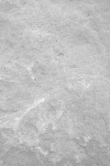 Light grey rough stone wall for abstract background and texture for interior or exterior design. Beautiful patterns, space for work, banner, wallpaper close up.Vertical.