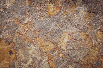 Brown grey rough stone wall with surface black orange rusted for abstract background and texture, interior or exterior design. Beautiful patterns, space for work, banner, close up.