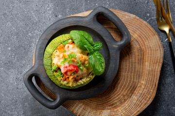 Stuffed zucchini pot with cheese and basil on the table top view