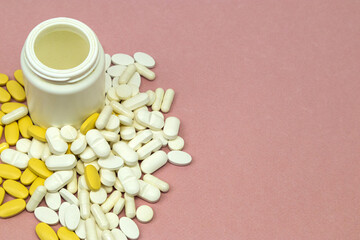Open purple pill bottle with pills scattered on a surface. Medical treatments, vitamins, supplements and general health concepts.