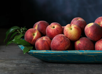 Still life of peaches in a serving bowl.