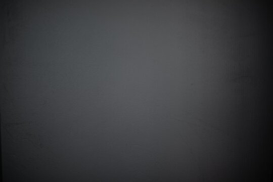 Close-up of a plain dark gray wall with a smooth, slightly textured surface. The minimalist and neutral background is perfect for use in design, presentations, or as a backdrop for creative projects