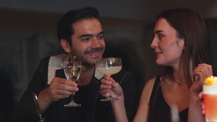 Smart couple making a toast with cocktail cheers in martini with olive and margarita savoring tasty enjoy drinking in lively conversation in good mood at bar refreshing special at nightclub. Vinosity.