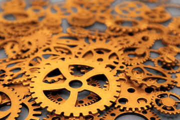 Brass gears and cogwheels, closely packed together. Mechanical intricacy and precision. Mechanical systems, teamwork, technology, automation and productivity -concepts. 