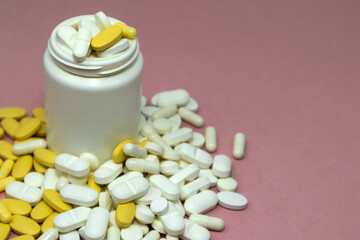 Open purple pill bottle with pills scattered on a surface. Medical treatments, vitamins, supplements and general health concepts.