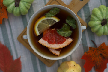 healthy healing vitamin tea. autumn picnic with tea in nature. in a white cup tea with citrus...