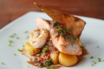 Delicious grilled salmon fillet served with grilled shrimp and potatoes