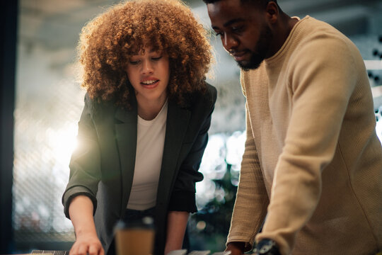 Diverse colleagues analyzing and discussing paperwork at modern office