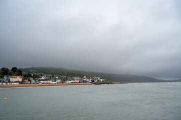 Lyme Regis town in Dorset under grey cloudy storm clouds by the English Channel, England