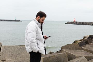 Virtual communication. Portrait of interesting and handsome european man holding telephone while texting.