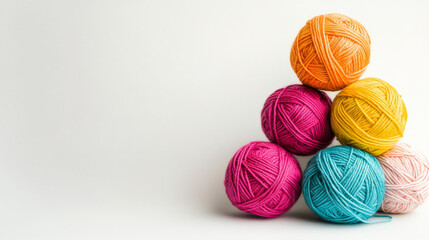 Colorful balls of yarn against a white backdrop.