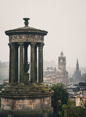 Dugald Stewart Monument in Calton Hill, Edinburgh, Scotland. The cityscape including Balmoral Hotel and Scotts Monument are visible in the background.