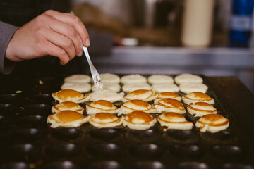 Girl Cooking small pancakes. Healthy street food. Cooking.
