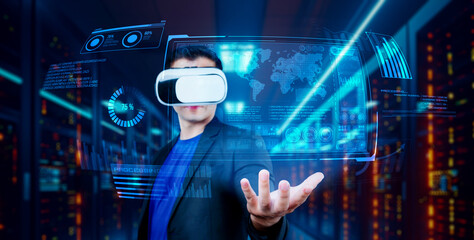 Project manager holding financial hologram while wearing VR glasses at data center. Professional business man looking and accessing at marketing data by using augmented reality technology. Ingenuity.