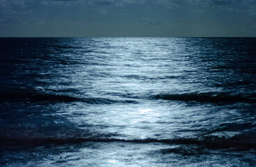 Moonlight reflection on the sea at night, creating a background.
