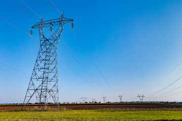 Fototapeta na wymiar High voltage pylon in the French countryside. High voltage electric power grid. High voltage power line in an agricultural landscape.