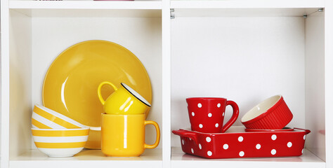 Shelves in wooden rack with colorful dishes close up
